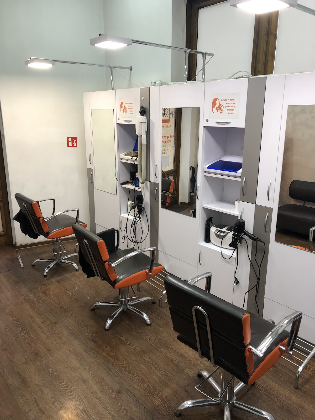 Stanowiska fryzjerskie z lustrami i fotelami w salonie Hair Beauty Style